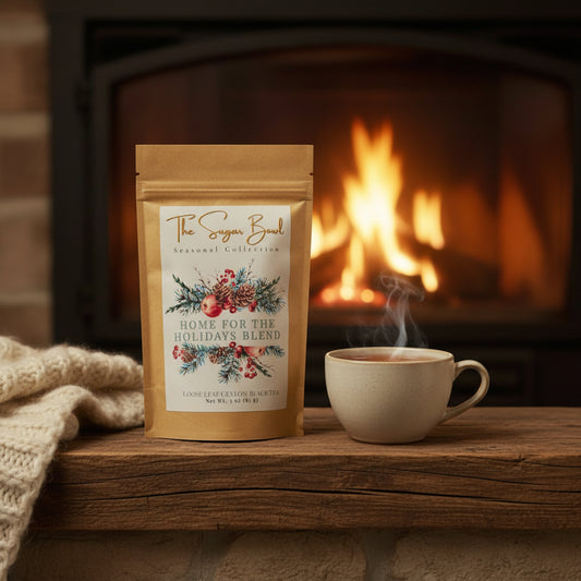 Tea package labeled 'Home for the Holidays Blend' from 'The Sugar Bowl' on a wooden surface.