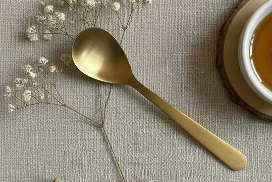 Gold spoon on a textured gray background